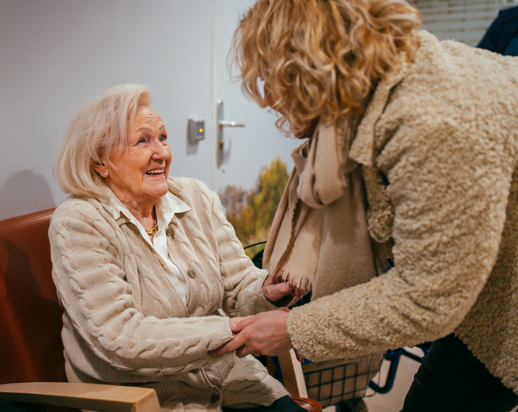 Blije oudere vrouw houdt hand vast van hulpverlener